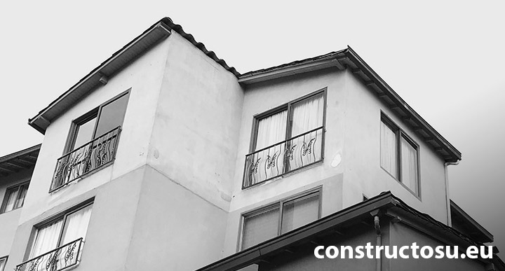 Etaj mansardat la o casa cu ferestre înalte și balustradă metalică