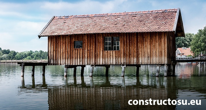 Casă din lemn construită pe un ponton pilonat.